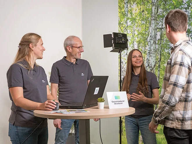 Gruppe im Gespräch an einem Stehtisch, im Hintergrund Kamera und Videolicht für ein Lernvideo.