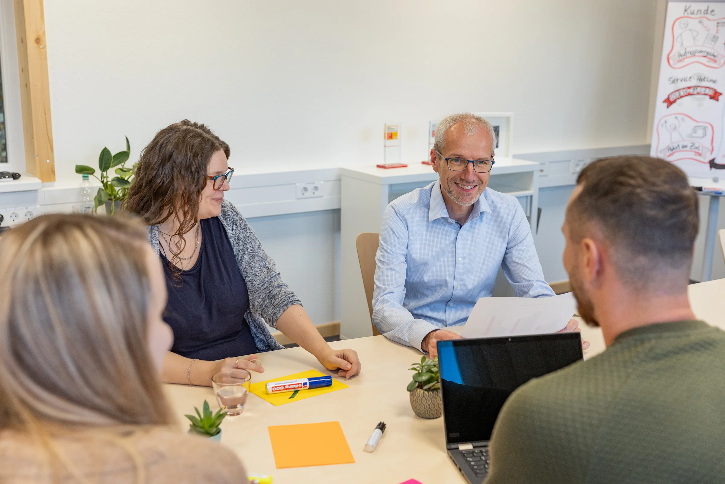 Team von GemeindebriefDruckerei im Gespräch bei einer Besprechung im Büro.